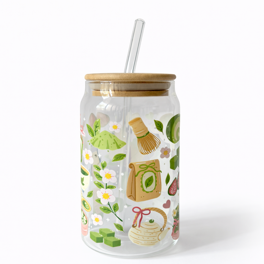 Clear tumbler with wooden lid and straw featuring illustrations of a basket, flowers, and other items on a white background.