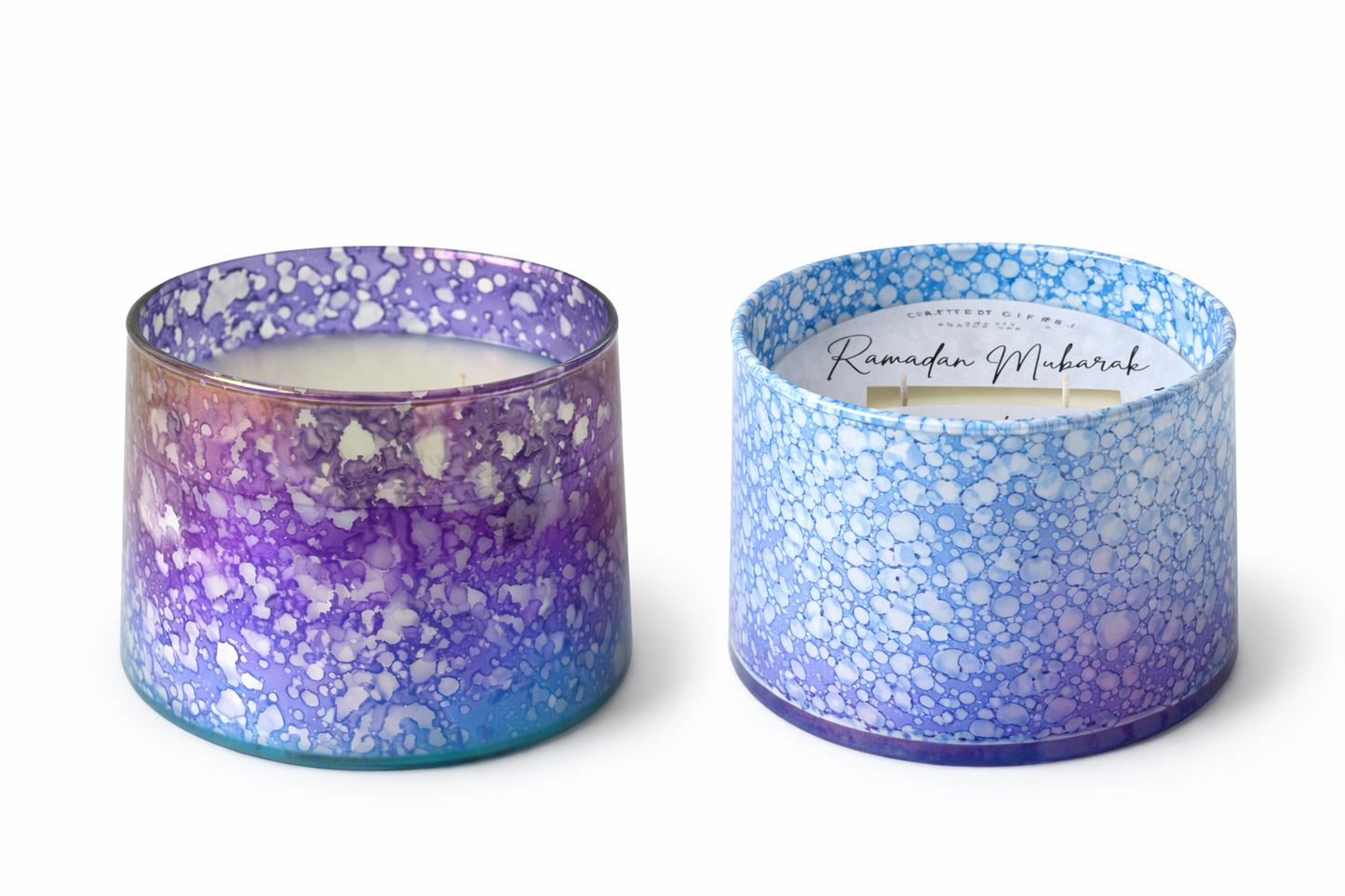 Two decorative candles with purple and blue speckled designs on a white background
