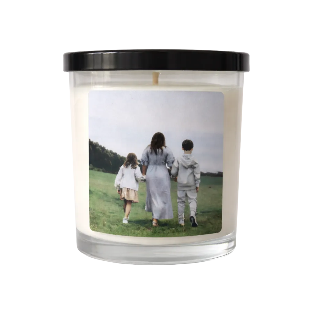 Candle with a printed photo of three people walking on a field on its label.