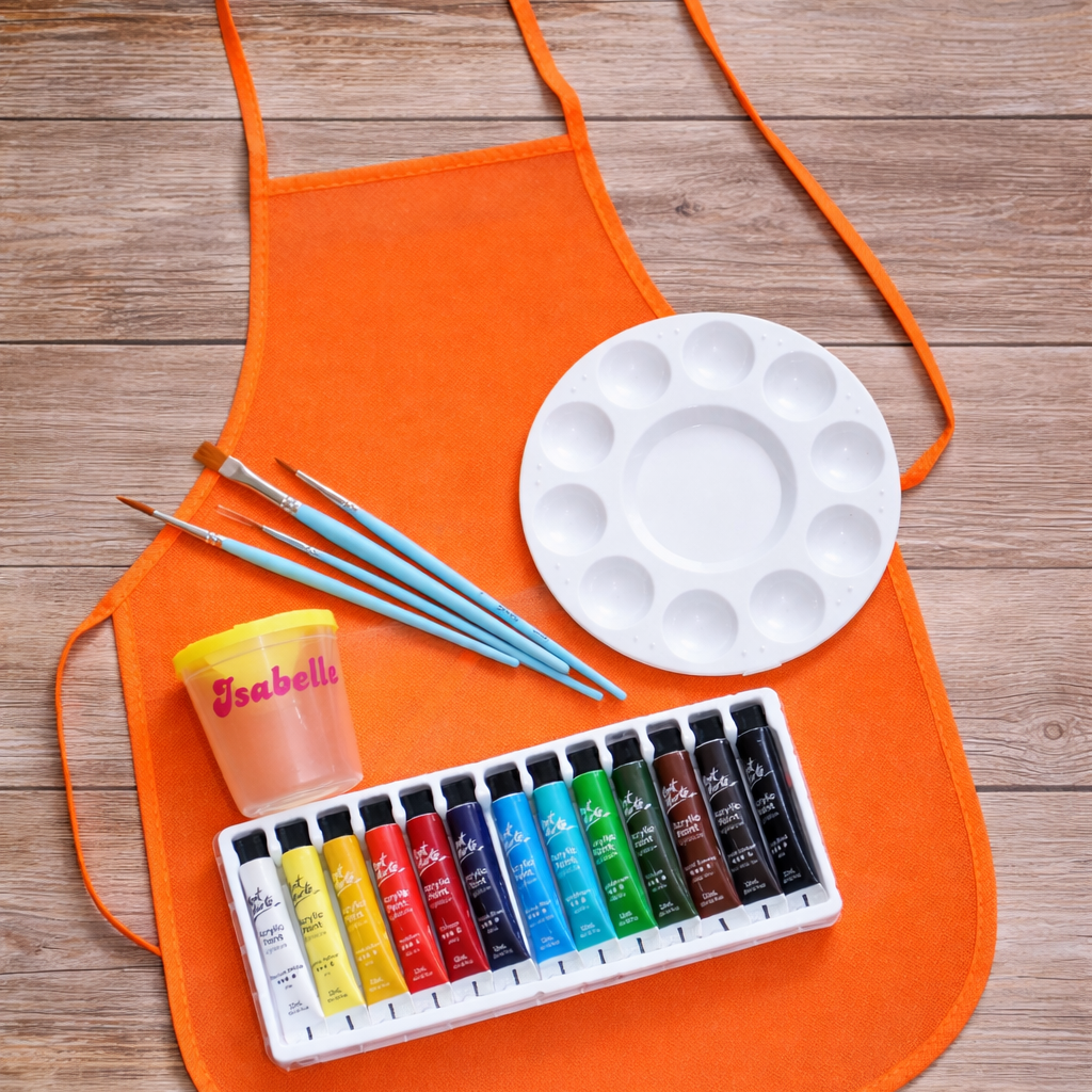 Orange apron with art supplies including watercolors, paintbrushes, and a palette on a wooden surface.