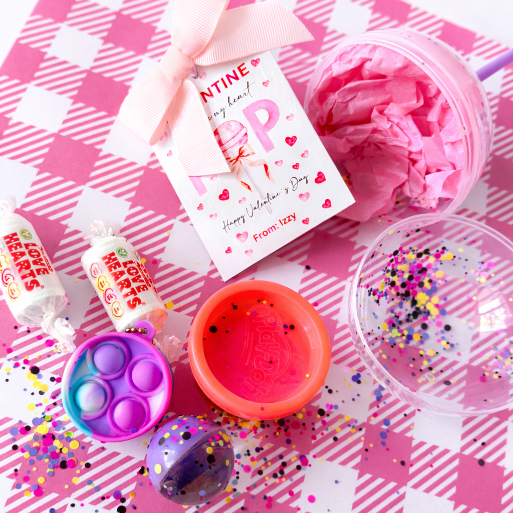 Pink and purple party supplies on a pink checkered tablecloth