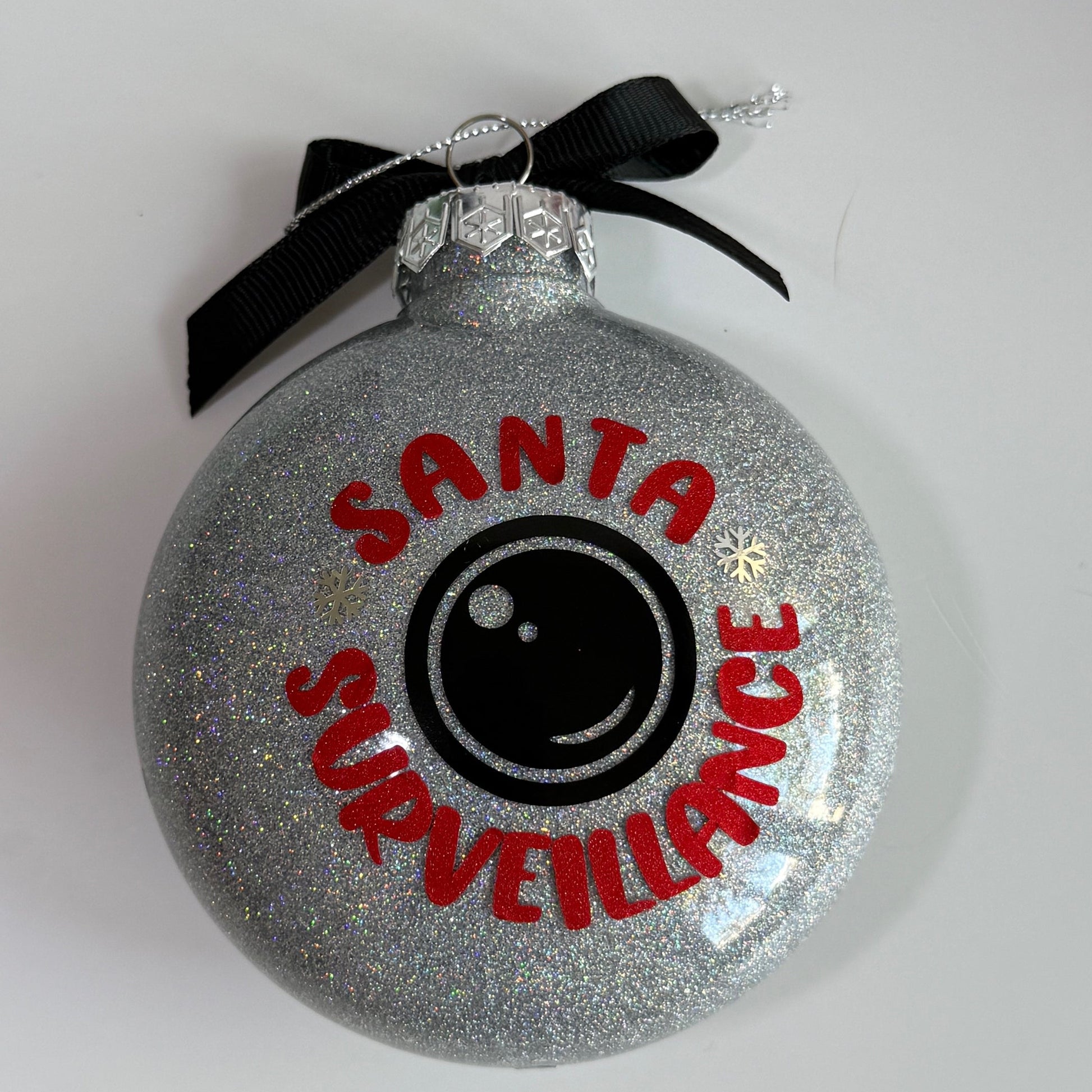 Decorative ornament with 'Santa's Surveillance' text on a white background