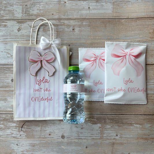 Set of three small bags with pink floral designs on a wooden surface