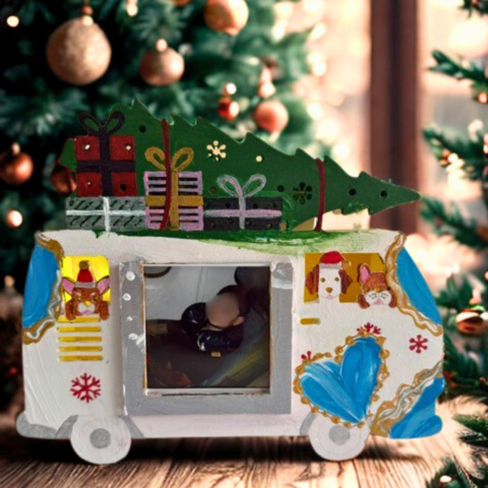 Decorative camper ornament with a picture frame on a Christmas tree