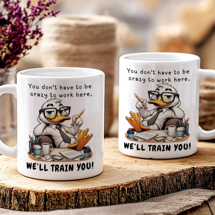 Two mugs with cartoon character design and humorous text on a wooden surface.