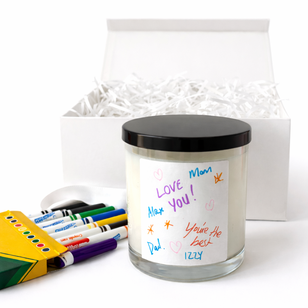 Candle with personalized message, markers, and gift bag on a white background