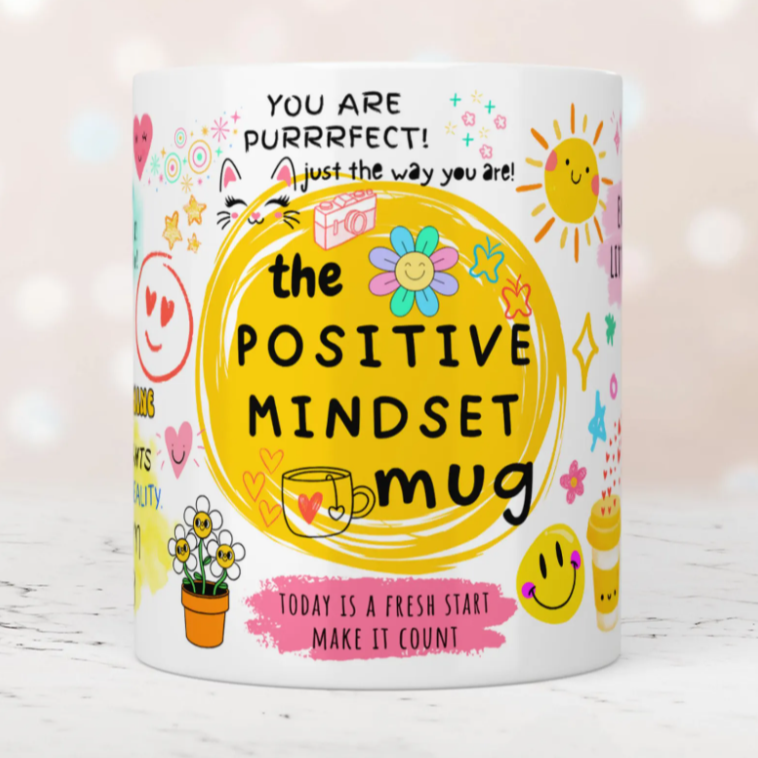 Colorful mug with motivational text and graphics on a light background