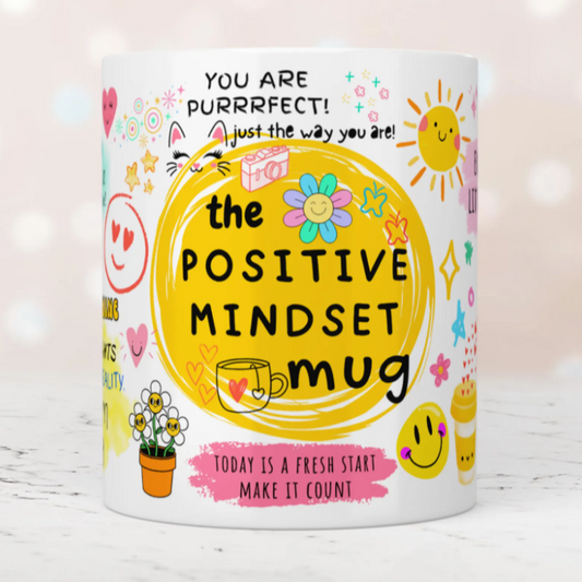 Colorful mug with motivational text and graphics on a light background