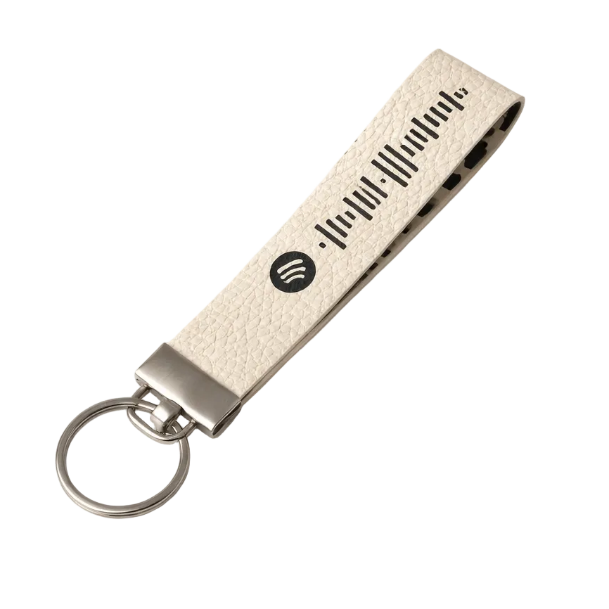 Beige keychain with a textured surface and Spotify logo on a white background